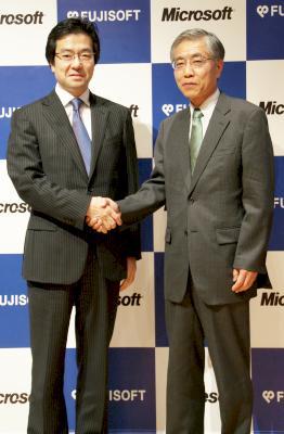 記者発表会の会場で固く握手を交わすマイクロソフトの樋口 泰行代表執行役社長（左）と富士ソフトの白石 晴久代表取締役社長