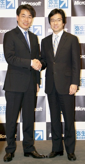 記者発表会後に固く握手をする弥生の岡本浩一郎代表取締役社長（左）とマイクロソフトの樋口泰行代表執行役社長